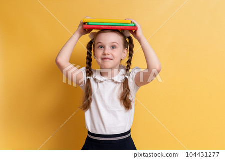 funny child schoolgirl. girl goes to school on yellow background. High quality photo 104431277