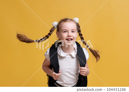 funny child schoolgirl. girl goes to school on yellow background. High quality photo 104431286