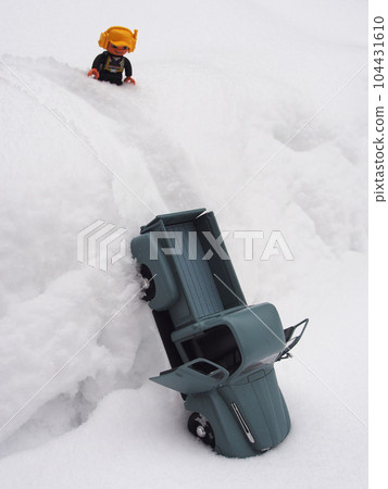 A toy car with a Christmas tree toy in the back and a figure of the driver are standing in the snow. A toy car with a Christmas tree toy in the back and a figure of the driver are standing in the snow. 104431610