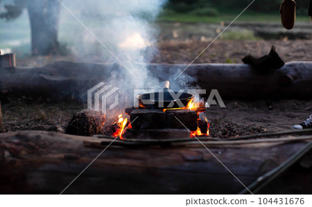 A hot frying pan on a fire. Cooking food in nature, close-up 104431676