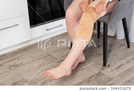 Orthopedic medical kneecap on the leg of a girl. Fixation and support of the knee joint after injury. 104431678