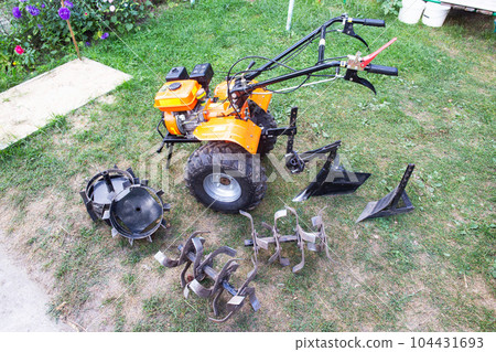 Agricultural walk-behind tractor with a set of attachments, hiller, milling cutters and lugs. Two-wheel tractor, industry 104431693