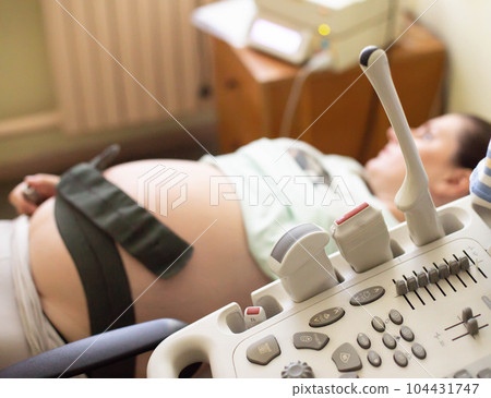 Pregnant girl on ultrasound examination during pregnancy. Study of the size of the fetus, fetometry, size and location of the placenta. Copy space for text 104431747