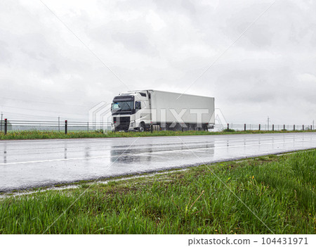 A truck with a refrigerated belt semi-trailer transports perishable goods on a highway in rainy weather. Copy space for text A truck with a refrigerated belt semi-trailer transports perishable goods on a highway in rainy weather. Copy space for text 104431971
