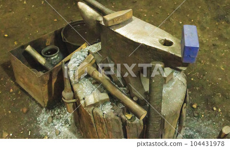 Anvil in the forge and a lot of hammers. Workshop for working with iron. industry Anvil in the forge and a lot of hammers. Workshop for working with iron. industry 104431978