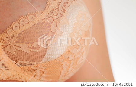 Bra on the female breast with special inserts to protect the female breast from getting wet with milk, close-up Bra on the female breast with special inserts to protect the female breast from getting wet with milk, close-up 104432091