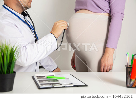 A pregnant girl with a big belly at the reception of an obstetrician-gynecologist. Observation of pregnancy and risks of complications. 104432101