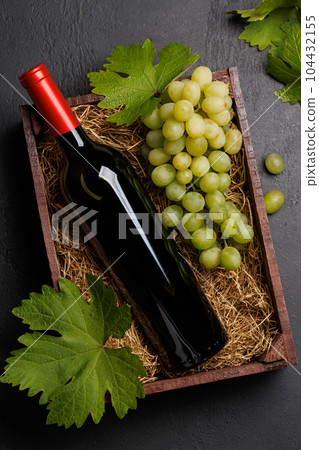 A red wine bottle and fresh grapes 104432155