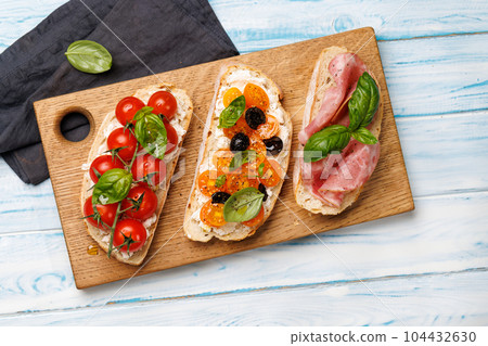 Sandwich set of bruschetta with juicy tomatoes, cheese and prosciutto Sandwich set of bruschetta with juicy tomatoes, cheese and prosciutto 104432630