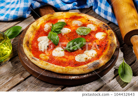 Margarita pizza with tomatoes, mozzarella cheese and basil 104432643