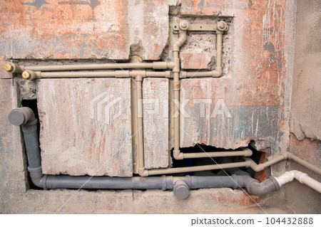 Transfer of water pipes and sewerage drain in the wall. Bathroom plumbing installation, background. Replacement of iron pipes with polypropylene ones. 104432888
