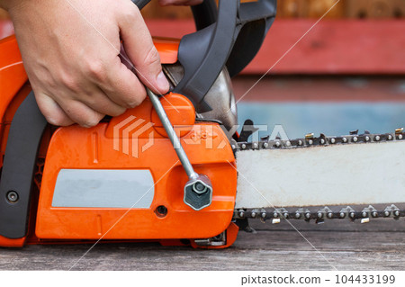 Correct chain tension using the special tool on the chainsaw bar. Chain tension adjustment. 104433199