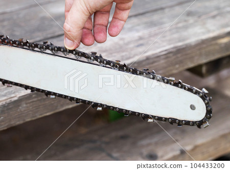 Correct chain tension using the special tool on the chainsaw bar. Chain tension adjustment. 104433200