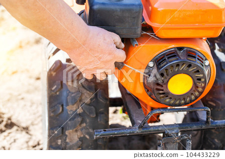 Manual start of the walk-behind tractor starter at the first start, running in. Industry 104433229