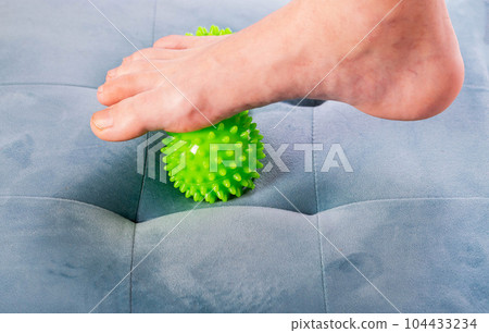 Medical foot massager. Removal of fatigue on the legs, relaxation. Home physiotherapy. Close-up Medical foot massager. Removal of fatigue on the legs, relaxation. Home physiotherapy. Close-up 104433234