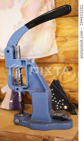 A metal device for riveting buttons on clothes. Close-up 104433281