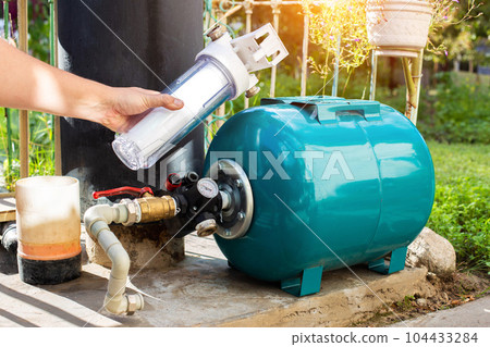 Water supply system from a well in a country house. New water filter. Hydraulic accumulator for storing water volume. Replacing a new water filter. Water supply system from a well in a country house. New water filter. Hydraulic accumulator for storing water volume. Replacing a new water filter. 104433284