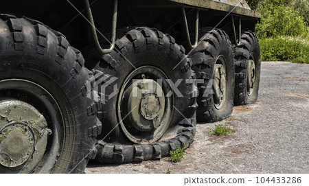 Flat and punctured wheels of armored personnel carriers during a military battle. Military conflict and weapons. Flat and punctured wheels of armored personnel carriers during a military battle. Military conflict and weapons. 104433286