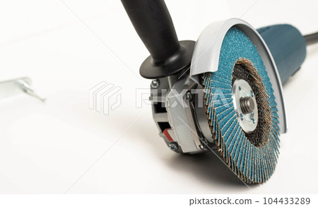Modern professional angle grinder with a flap wheel on a white background. Power tool for work. Sanding wood and metal. Modern professional angle grinder with a flap wheel on a white background. Power tool for work. Sanding wood and metal. 104433289