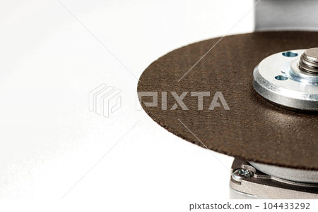 Angle grinder with reinforced cutting wheel for metal. Construction power tool, industry. Close-up 104433292