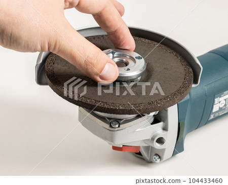 The worker tightens the clamping nut on the grinding wheel in the grinder before starting work. 104433460
