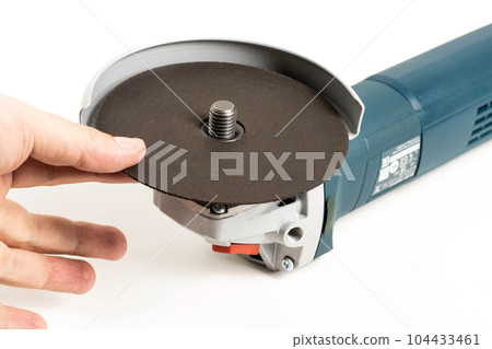 Installing a reinforced cutting wheel on an angle grinder for cutting metal. Close-up 104433461