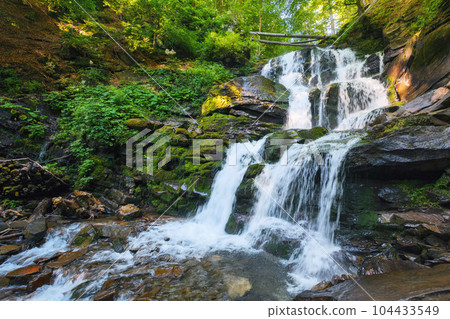 waterfall among wet rocks. fresh environment and clear water concept. summer nature scenery waterfall among wet rocks. fresh environment and clear water concept. summer nature scenery 104433549