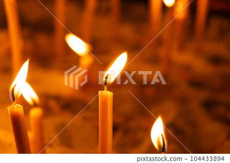 A lot of burning candles in the temple in the dark. The concept of religion, prayer and God. 104433894