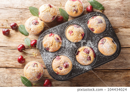 Cherry muffins fresh and homemade baked in a muffin pan closeup. Horizontal top view Cherry muffins fresh and homemade baked in a muffin pan closeup. Horizontal top view 104434024