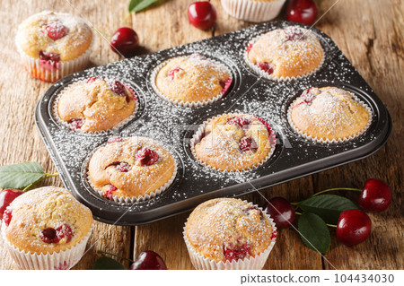 Cherry muffins fresh and homemade baked in a muffin pan closeup. Horizontal 104434030