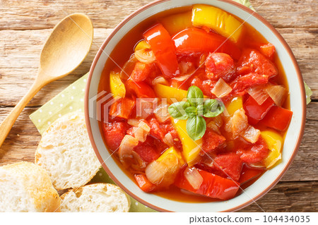 Delicious stewed colorful bell peppers with onions, garlic and tomatoes close-up in a bowl. Horizontal top view Delicious stewed colorful bell peppers with onions, garlic and tomatoes close-up in a bowl. Horizontal top view 104434035