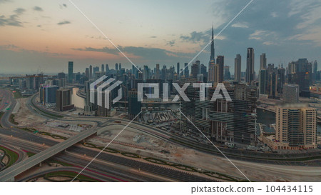 Skyline with modern architecture of Dubai business bay towers at sunset timelapse. Aerial view 104434115