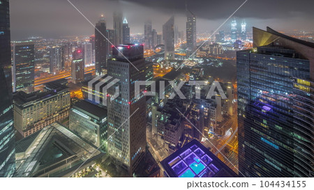 Panorama of futuristic skyscrapers in financial district business center in Dubai all night timelapse Panorama of futuristic skyscrapers in financial district business center in Dubai all night timelapse 104434155