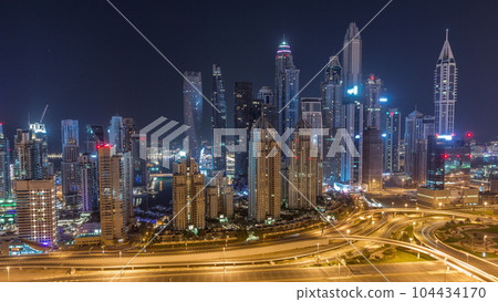 Skyscrapers of Dubai Marina near intersection on Sheikh Zayed Road with highest residential buildings all night timelapse Skyscrapers of Dubai Marina near intersection on Sheikh Zayed Road with highest residential buildings all night timelapse 104434170