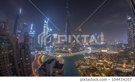 Skyscrapers rising above Dubai downtown all night timelapse surrounded by modern buildings aerial top view 104434207