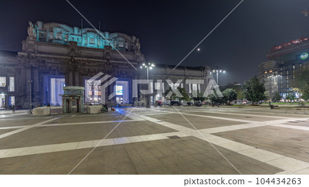 Panorama showing Milano Centrale night timelapse - the main central railway station of the city of Milan in Italy. Panorama showing Milano Centrale night timelapse - the main central railway station of the city of Milan in Italy. 104434263