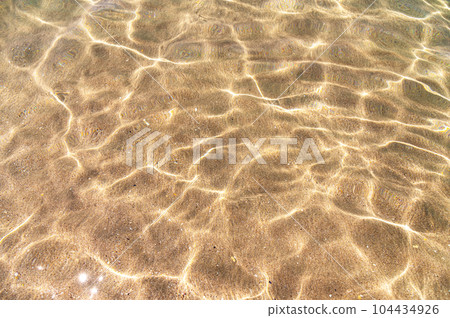 Transparent clear sea, close-up. Background. Sea sandy bottom. Top view across the water 104434926