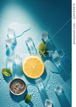 Creative summer composition with lemon slice, mint leaves, can of soda and ice cubes. Minimal lemonade drink concept. 104434974