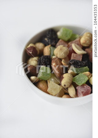 Nut mixture in a cup. A delicious snack of nuts and dried fruits. 104435353
