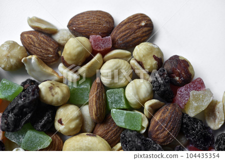 Nut mixture on a white background. A delicious snack of nuts and dried fruits. 104435354