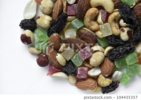 Nut mixture on a white background. A delicious snack of nuts and dried fruits. 104435357