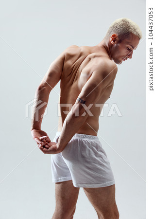 Strong, muscular, relief male back. Healthy body. Young man posing in underwear against grey studio background Strong, muscular, relief male back. Healthy body. Young man posing in underwear against grey studio background 104437053