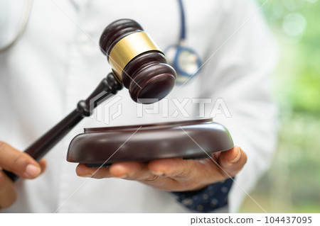 Doctor holding judge gavel, forensic medicine, medical law and crime justice concept. 104437095