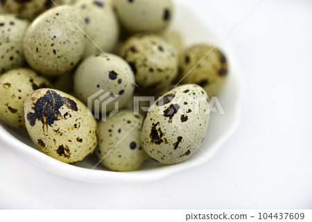Quail eggs in a white plate. Food eggs on a white background. 104437609