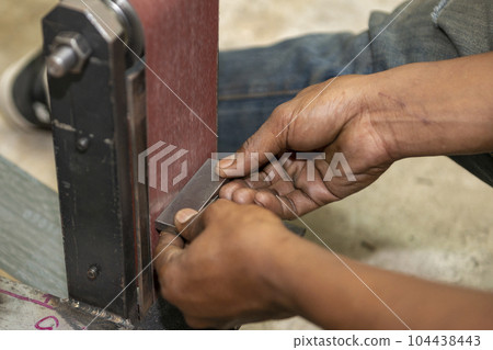 The manual hand grinding process on sandpaper belt machine. The manual hand grinding process on sandpaper belt machine. 104438443