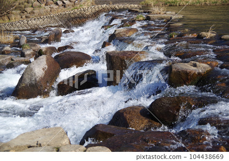 Flow of stone and water of river weir 104438669