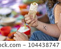 man is holding a burrito in his hand 104438747