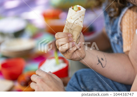 man is holding a burrito in his hand 104438747