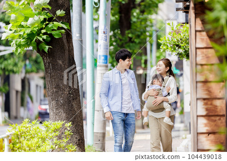 A couple walking with a child A couple walking with a child 104439018