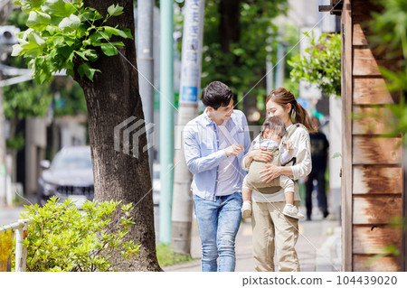 A couple walking with a child A couple walking with a child 104439020